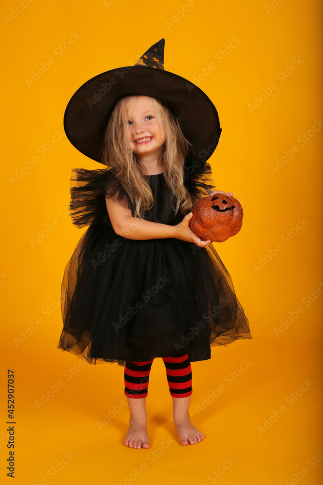 beautiful happy little blonde girl in a black dress black hat red tights with black stripes halloween holiday beautiful happy little blonde girl in a black dress black hat red tights with black stripes halloween holiday