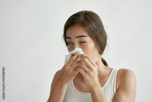 woman in white t-shirt blows her nose in a handkerchief depression infection