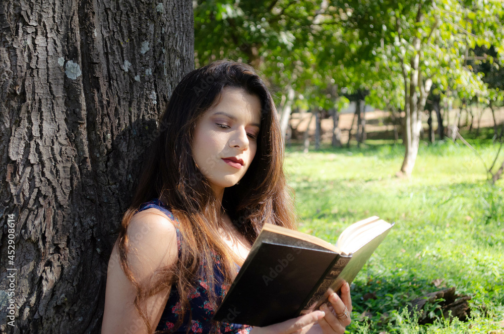 Fototapeta premium Woman reading in a park