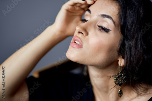 pretty woman with loose hair earrings posing close-up model
