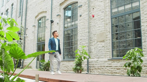 Wallpaper Mural A young successful businessman is walking down the street. Man in a casual wear. Business, freelance and remote work. Torontodigital.ca