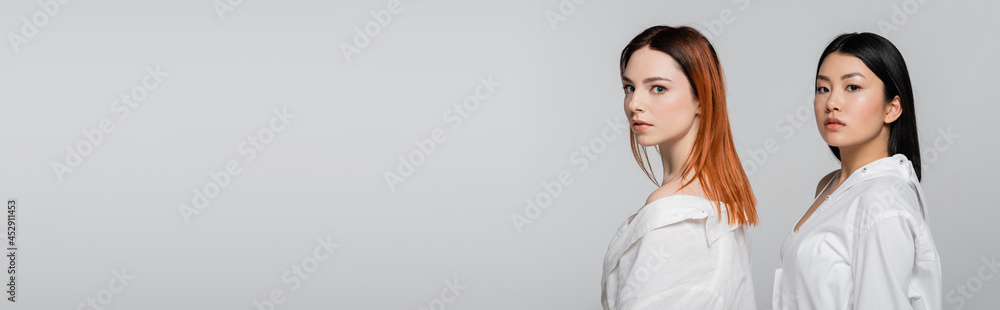 brunette asian and redhead models posing isolated on grey, banner brunette asian and redhead models posing isolated on grey, banner