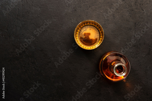 American bourbon whiskey in glass and bottle, black background with negative space