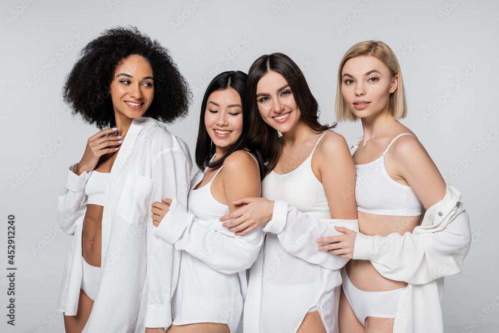 group of joyful multiethnic models smiling and posing isolated on grey group of joyful multiethnic models smiling and posing isolated on grey