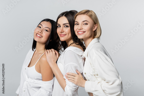 positive interracial models smiling isolated on grey