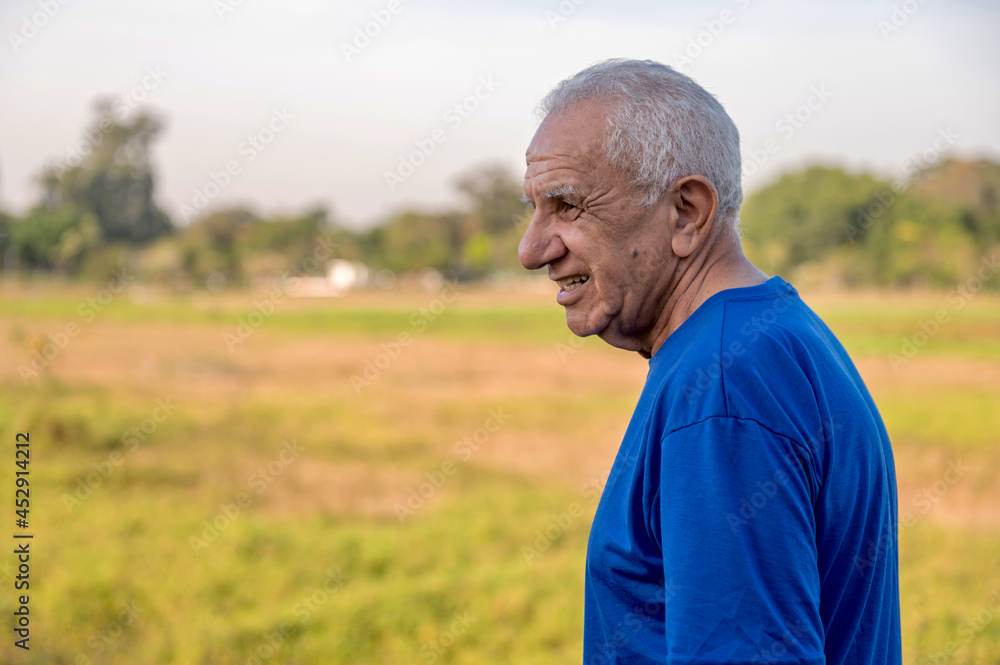 side portrait of a senior man outside in a park on a sunny day with copy space side portrait of a senior man outside in a park on a sunny day with copy space