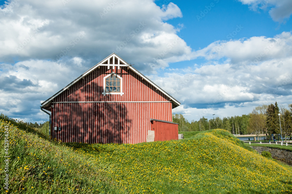 Old wooden building located on grassy hill during sunny day Old wooden building located on grassy hill during sunny day