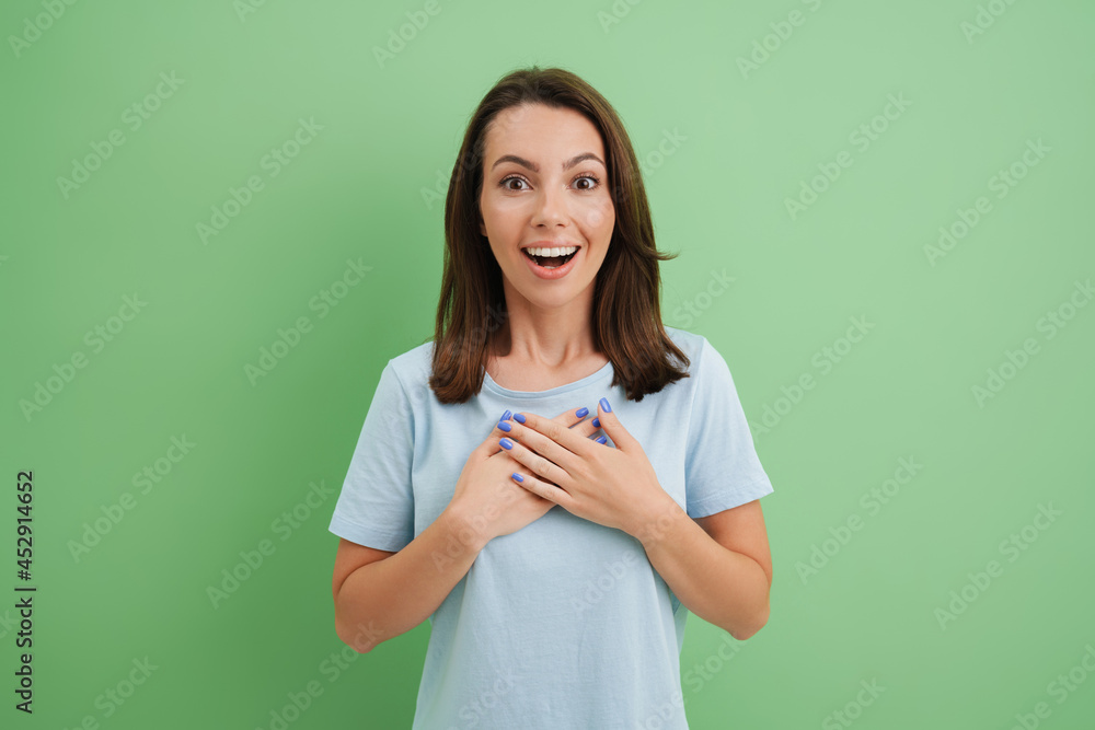 Young european woman smiling while holding hands on her chest Young european woman smiling while holding hands on her chest