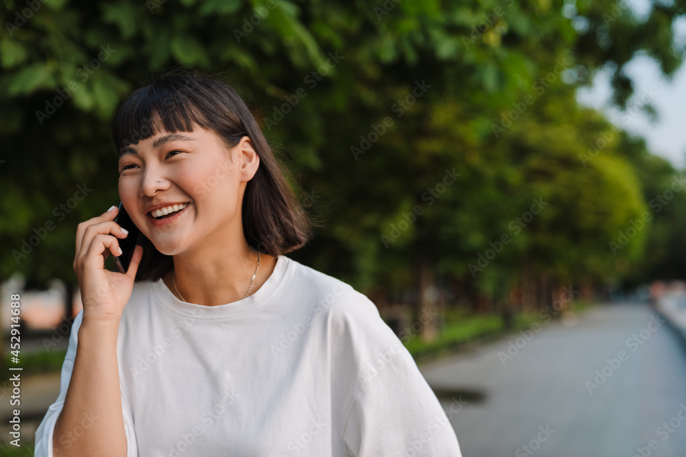Smiling young asian woman walking in a green park Smiling young asian woman walking in a green park