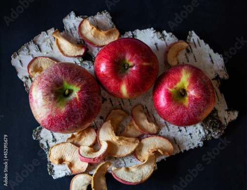 Red apples on birch bark, dark background, dryfruits