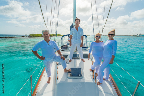 Senior and young couples, family, enjoying sailing trip on a luxury summer holiday vacation, sunny weather and ocean in background, love and romance on a beautiful yacht