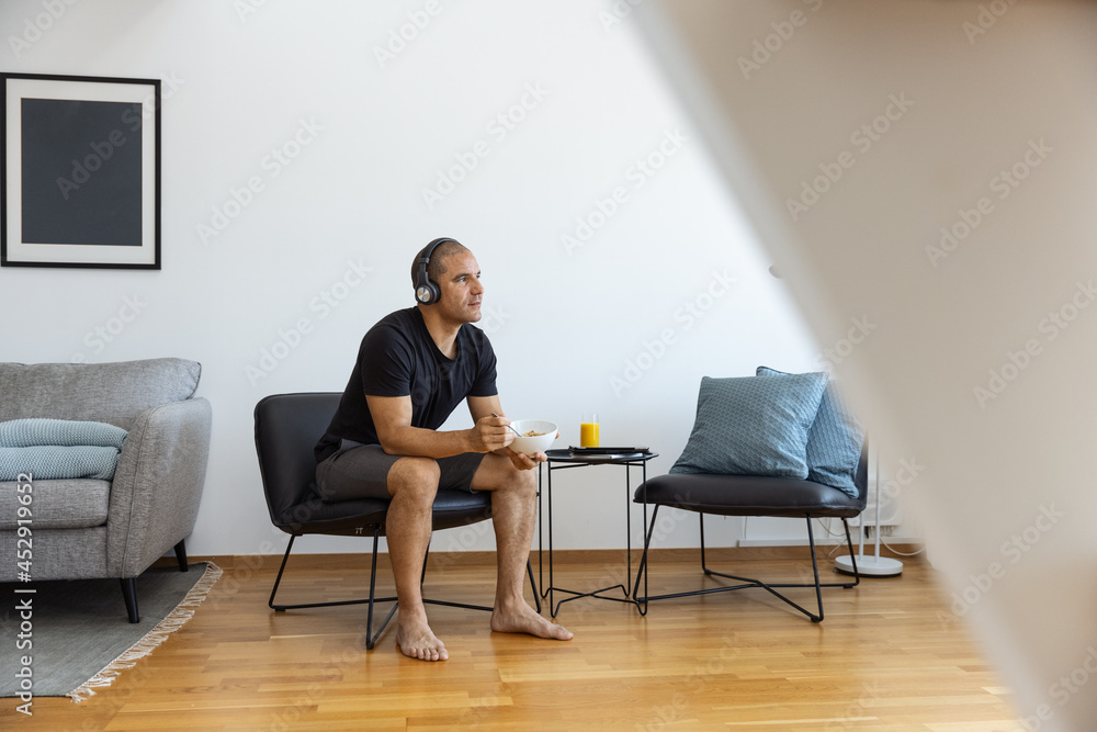 Serene man having breakfast in living room at home Serene man having breakfast in living room at home