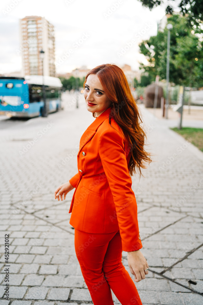 Trendy redhead woman walking in the city street Trendy redhead woman walking in the city street
