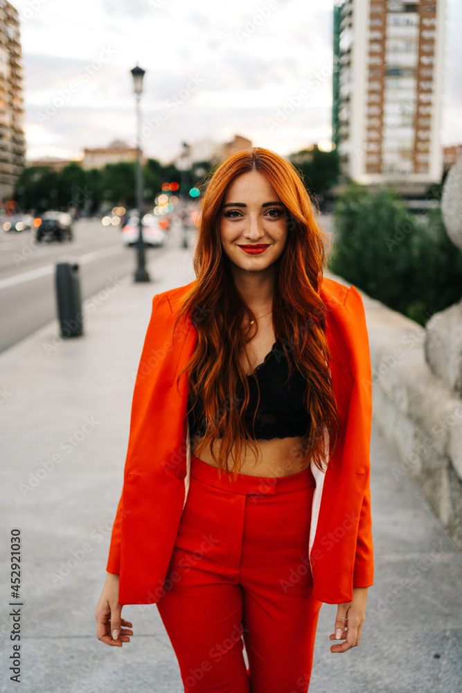 Content stylish redhead woman in suit in city Content stylish redhead woman in suit in city
