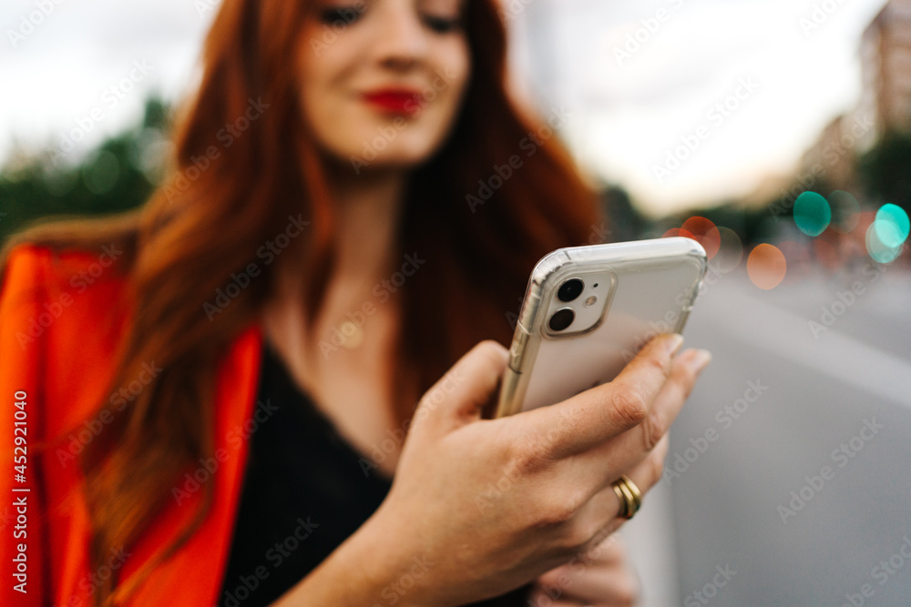 Redhead woman browsing on smartphone in city Redhead woman browsing on smartphone in city