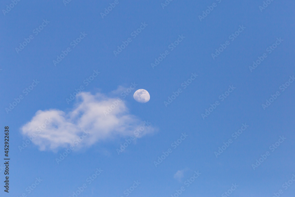 moon with white clouds blue background The afternoon moon has space for messages. moon with white clouds blue background The afternoon moon has space for messages.