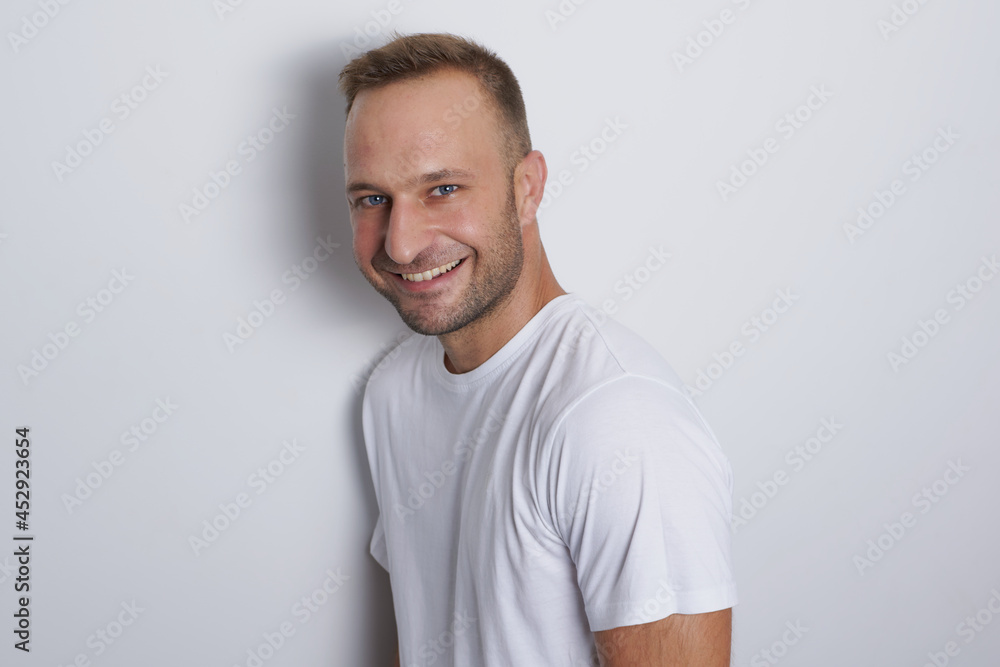 Obraz premium Man smiling in a white background with white t-shirt