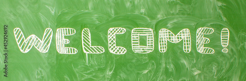 The inscription in English is welcome, written in handwritten font on a green school blackboard with traces of chalk and space for copying. Concept - back to school
