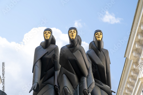 three statues with the golden mask in vilnius photo