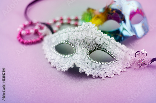 A festive,Beautiful white mardi gras or carnival mask on beautiful purple paper background.
