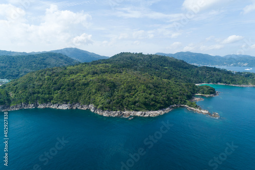 High angle view Tropical sea with wave crashing on seashore and high mountain located in Phuket Thailand aerial view drone top down Amazing nature view landscape Beautiful sea surface. © panya99