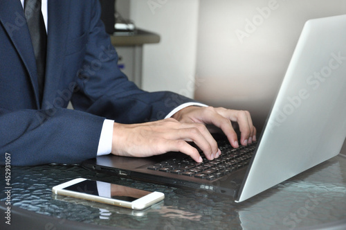man in business suit typing laptop, selective focus
