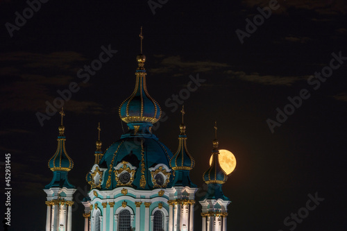 The full moon shines through the tower of St. Andrew's Church, Kiev, Ukraine photo