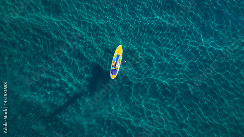 Photography Aerial photo of man on sup board in clear blue sea