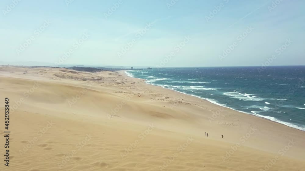 Handheld shot of Japan Sea from the Umanose hill (the horse’s back) at Tottori Sand Dunes (Tottori Sakyu) in sunny day with blue sky. They form the large dune system over 2.4 km in Sanin, Japan Handheld shot of Japan Sea from the Umanose hill (the horse’s back) at Tottori Sand Dunes (Tottori Sakyu) in sunny day with blue sky. They form the large dune system over 2.4 km in Sanin, Japan