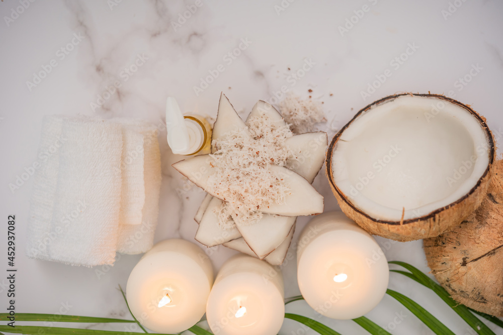 Coconut oil, tropical leaves and fresh coconuts. Spa coconut products on light wooden background. Spa still life of organic cosmetics with coconuts on a light wooden background, body care concept. Coconut oil, tropical leaves and fresh coconuts. Spa coconut products on light wooden background. Spa still life of organic cosmetics with coconuts on a light wooden background, body care concept.