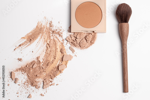 Set of liquid face powder, bronzing powder and smashed finishing powder with vegan zero waste wood make up brush isolated on white background.