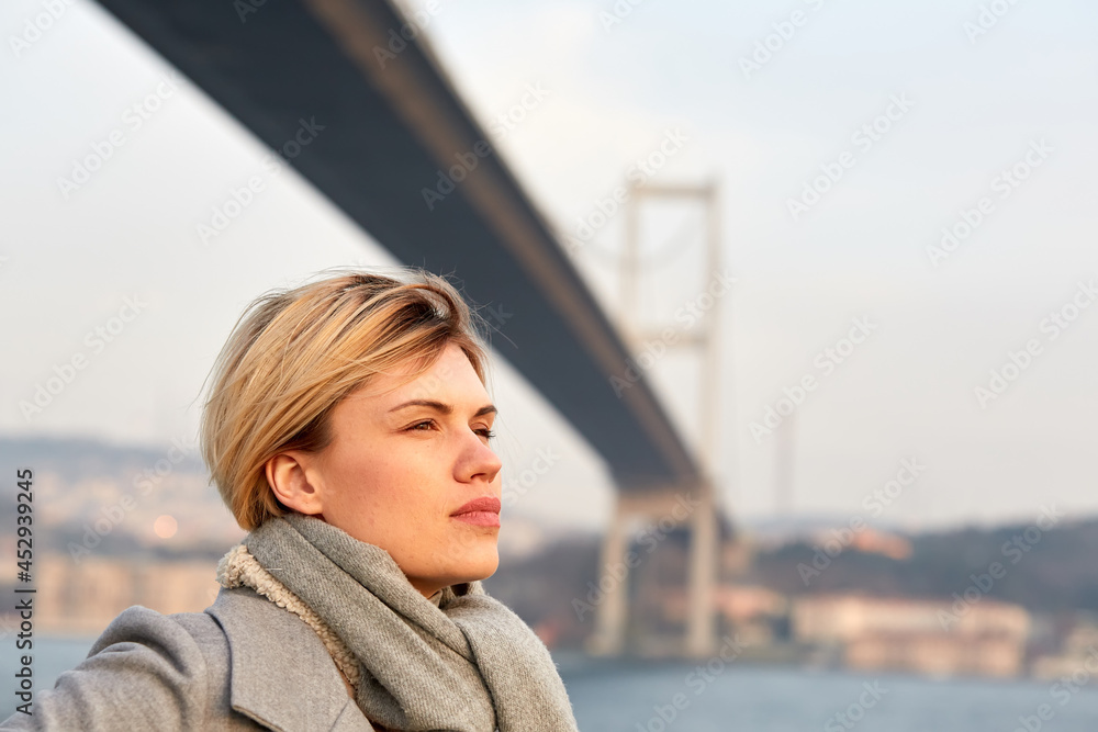 Portrait of a young woman under the Bosporus bridge.