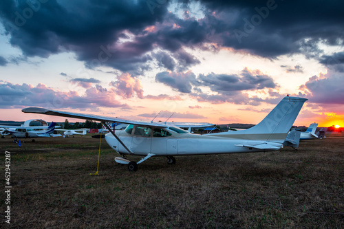Small private airplanes parked at the airfield at scenic sunset