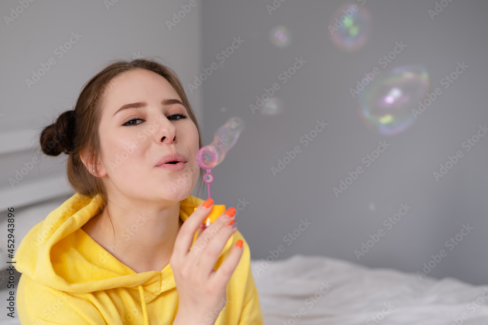 woman in yellow among soap bubbles on grey background woman in yellow among soap bubbles on grey background