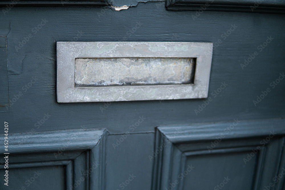 Old letterbox in the door, traditional way of delivering letters to the house, old mailbox, correspondence