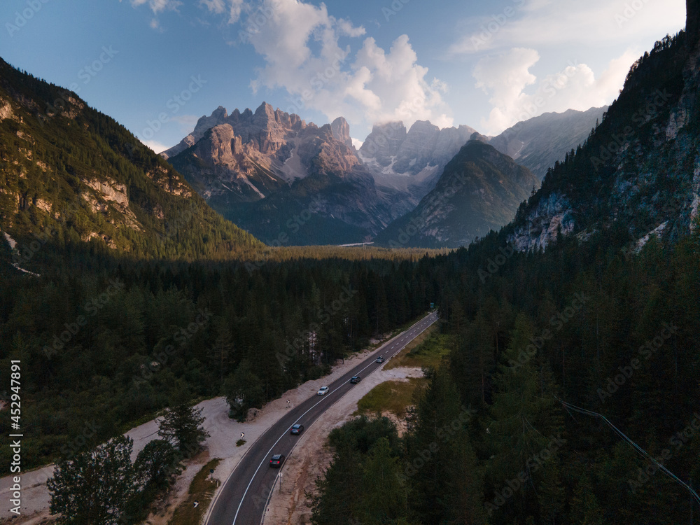 View from the drone to the forest and mountains  in the Dolomites of South Tyrol. Flying over the clouds in the Italian Alps