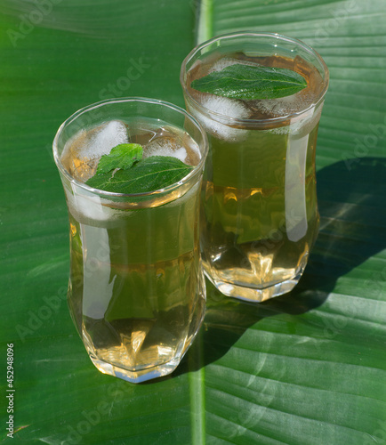 Iced tea made with fake Melissa (Lippia alba) on a banana leaf, drink for Brazilian spring-summer. photo