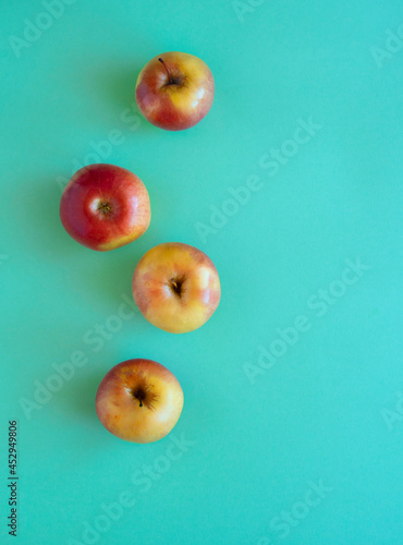 Red-yellow ripe apples on a green background. flat lay.