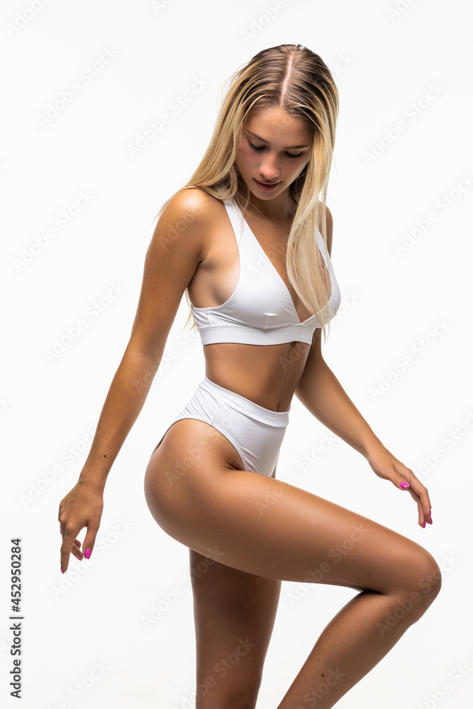 Foto de Feeling so happy. Atractive young woman in tank top and panties  posing against white background do Stock