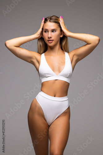 Close up photo of slim woman's body in white lingerie isolated on white background
