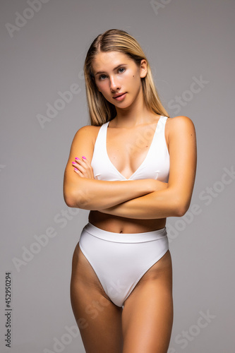 Body Care. Beautiful Woman In Shape With Fit Slim Body, Healthy Smooth Soft Skin In White Bikini Panties On Gray Background.