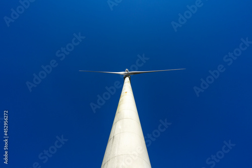 View from below of wind and renewable energy masts with their large propellers and turbines in a rural area in the north of Spain. Alternative and renewable energy concept. 