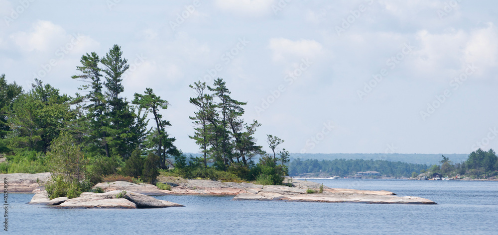 Smooth granite rocky shoreline with windswept pines in Georgian Bay Ontario Canada Smooth granite rocky shoreline with windswept pines in Georgian Bay Ontario Canada