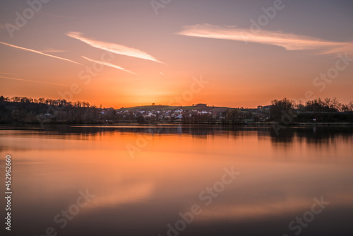 Landschaft und Sonnenuntergang am Ufer der Donau in Regensburg mit Blick zu der Ortschaft Kneiting, Deutschland