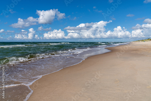 beautiful idyllic endless white sand beach with a calm ocean and gentle waves and sand dunes