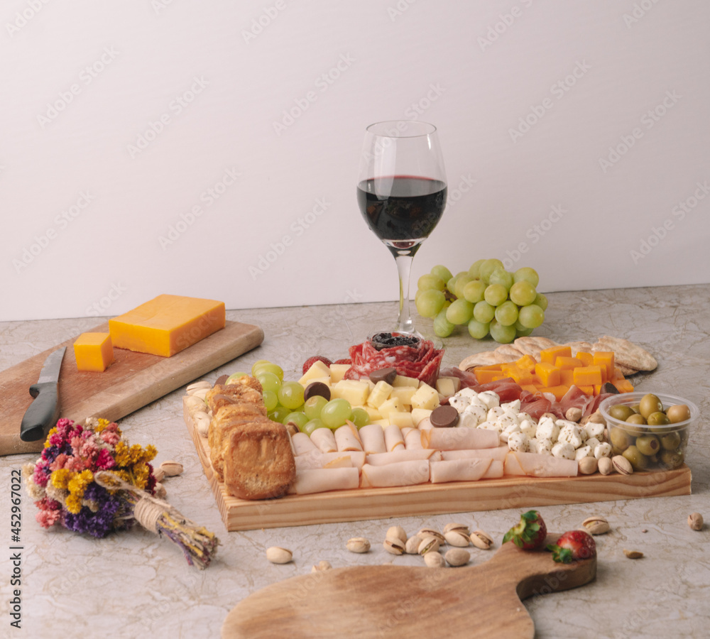 cheese platter on a marble table with fruit and wine cheese platter on a marble table with fruit and wine