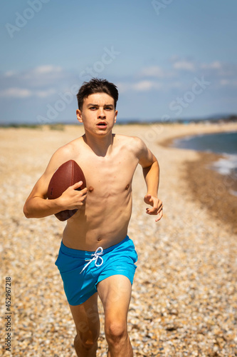 On a beach with an American Footbal