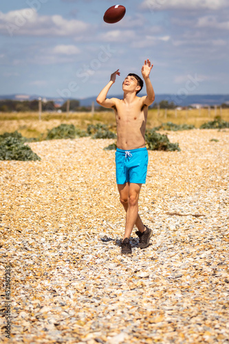 Fototapeta Naklejka Na Ścianę i Meble -  Running on a beach with an American Football