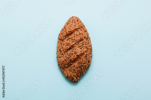 Bread, pastries on a colored bright background. Bread with sesame seeds and seeds, bread texture. Delicious flavored bun.