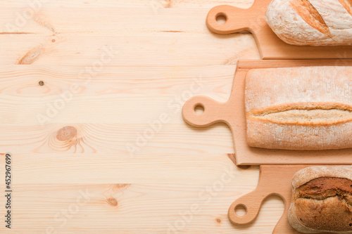 Bread, pastries on a light wooden background. Bread with sesame seeds and seeds, bread texture. Delicious flavored bun. Lots of airy fresh bread.